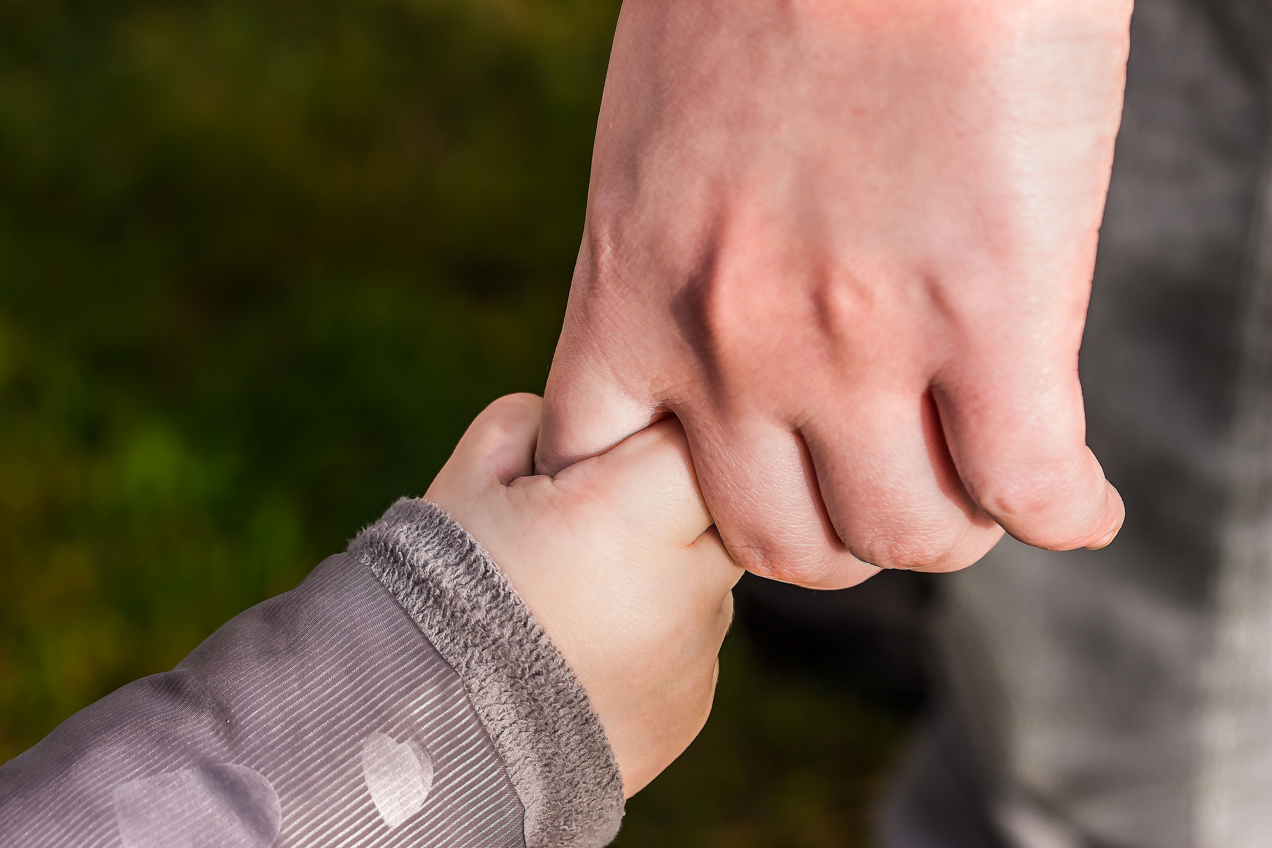 A parent holding a child’s hand